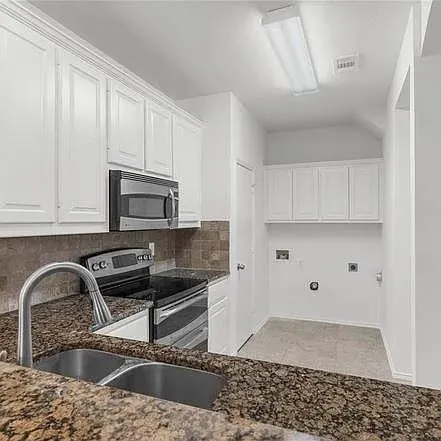 a kitchen with stainless steel appliances granite countertop a sink a stove and cabinets