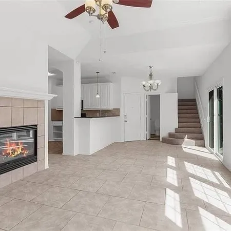 a view of kitchen and empty room with fireplace