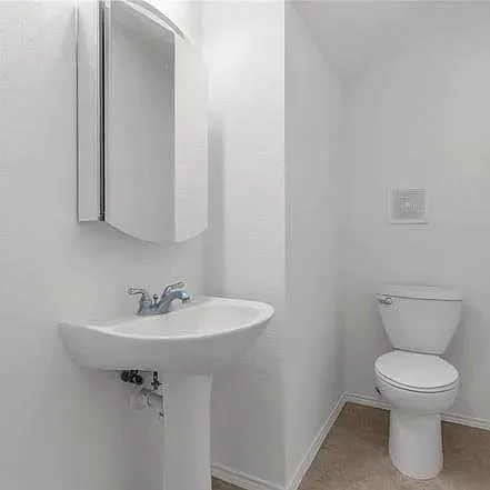 a bathroom with a sink toilet and a mirror