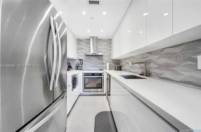 a kitchen with a sink stainless steel appliances and white cabinets