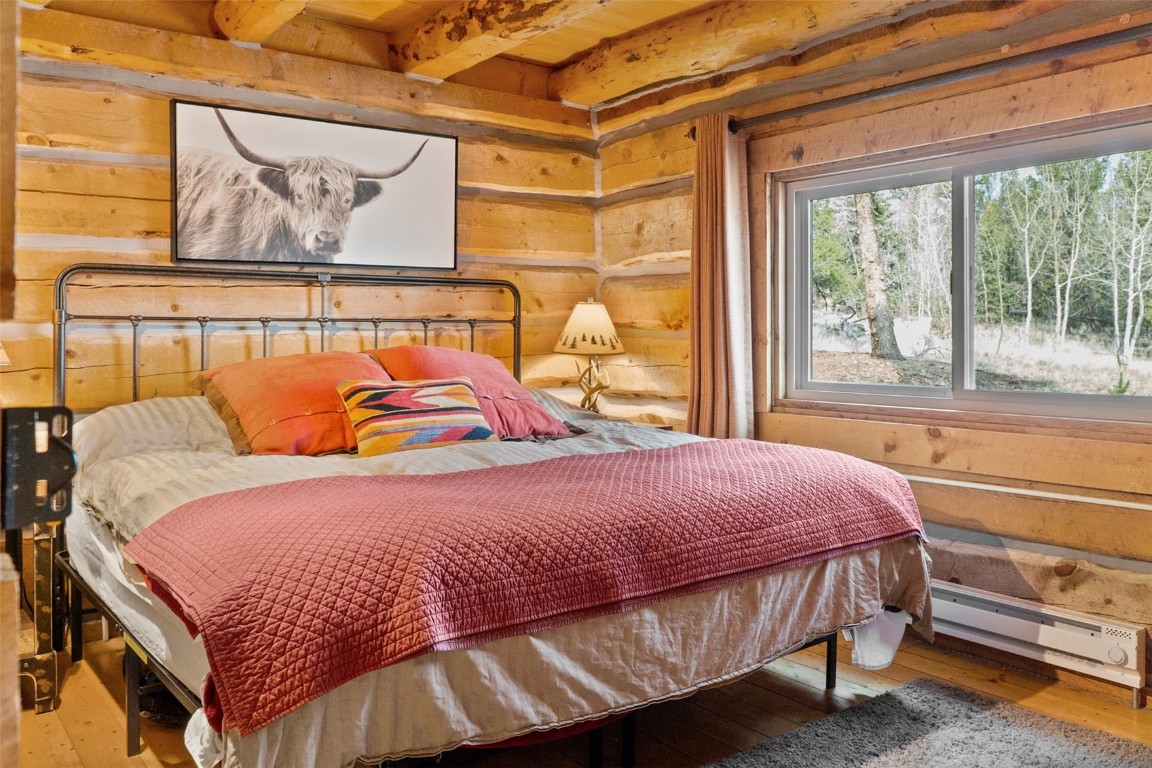 245 Bronco Circle Como, CO 80456 - Photo 21 of 40 a bedroom with a bed and wooden floor