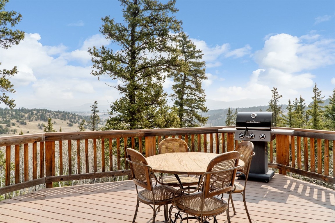 245 Bronco Circle Como, CO 80456 - Photo 33 of 40 a balcony with wooden floor table and chairs