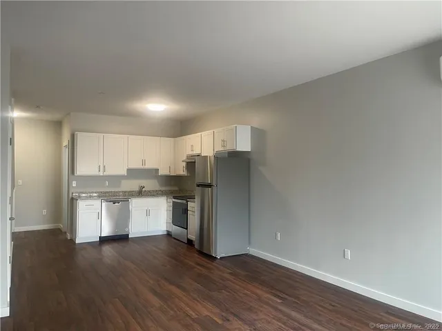 a kitchen with a refrigerator sink and cabinets