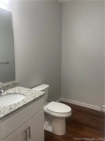 a bathroom with a granite countertop toilet and a sink