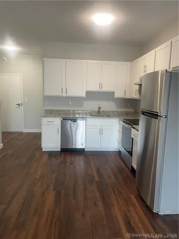 a kitchen with a sink stainless steel appliances and white cabinets