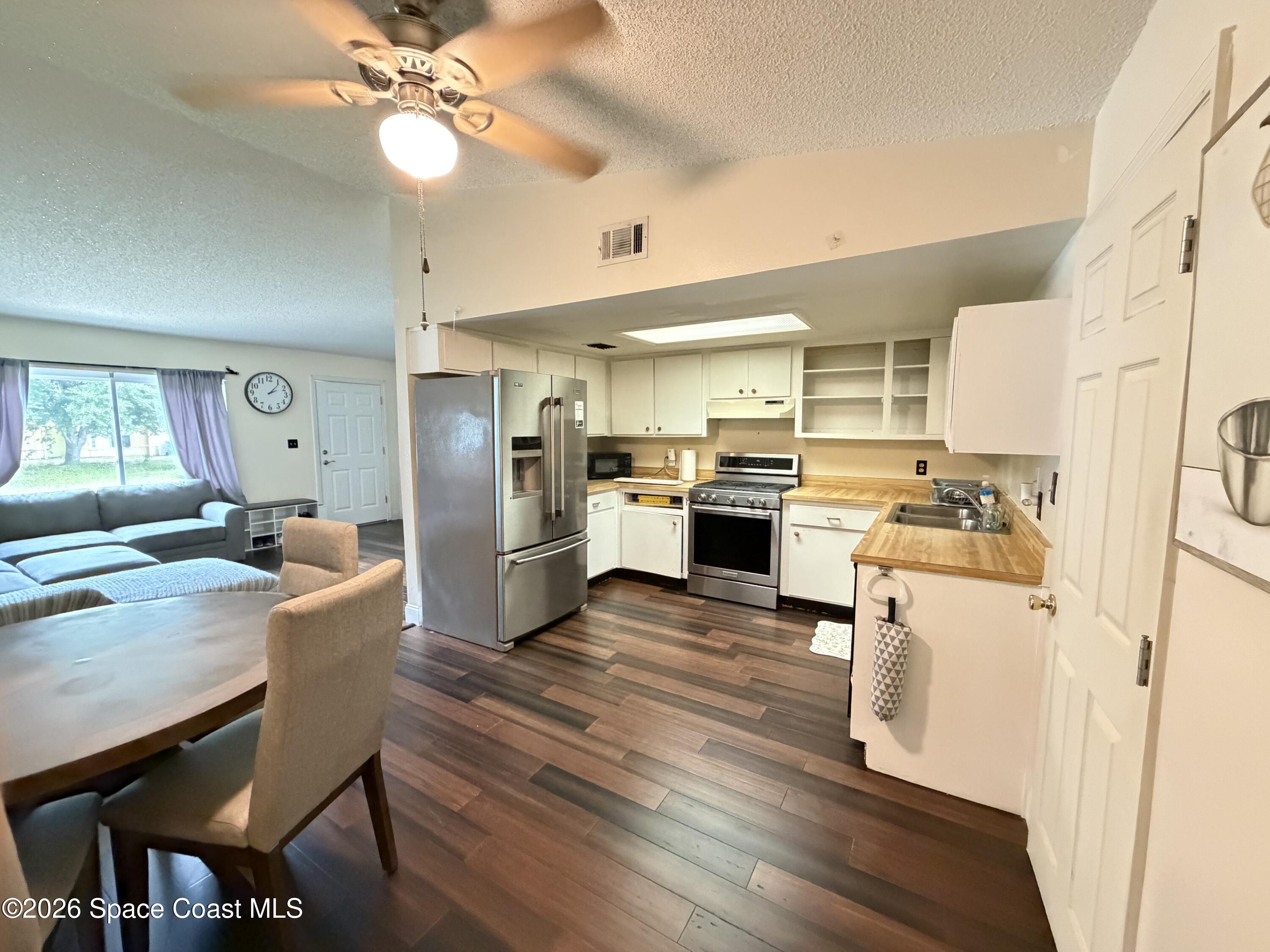 1578 West Powder Horn Road Titusville, FL 32796 - Photo 5 of 22 a kitchen with a table chairs refrigerator and microwave