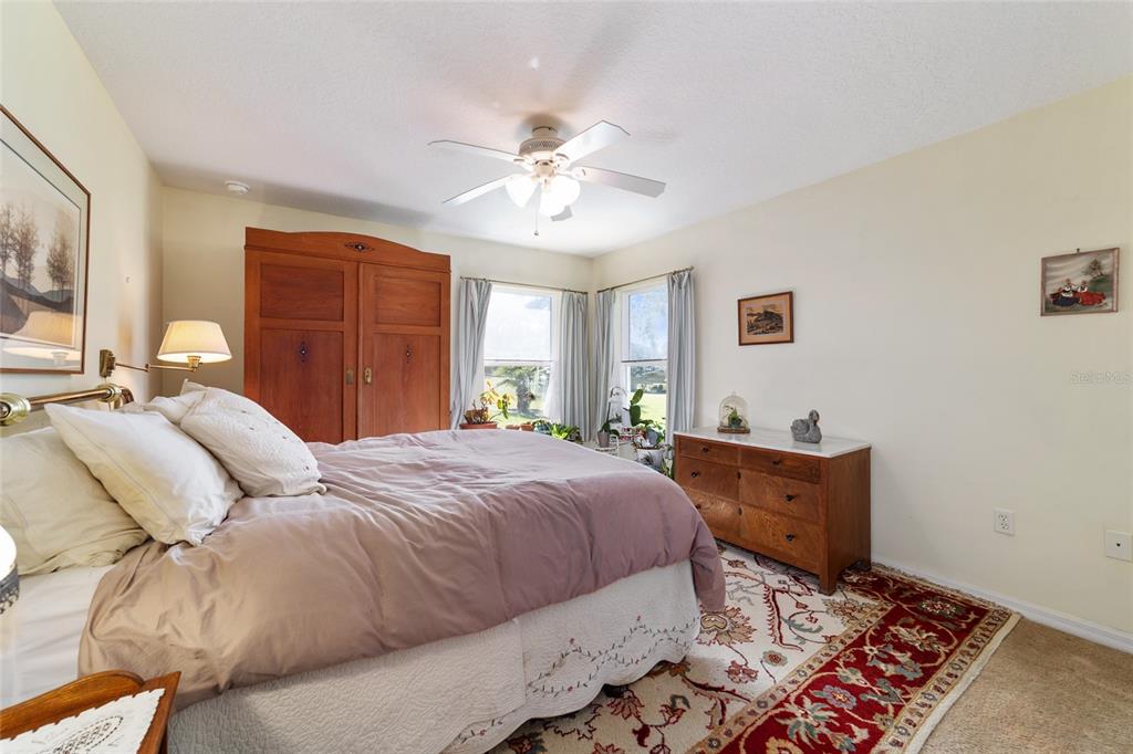 12932 Southwest 41st Place Ocala, FL 34481 - Photo 16 of 29 a bedroom with a bed and a chandelier