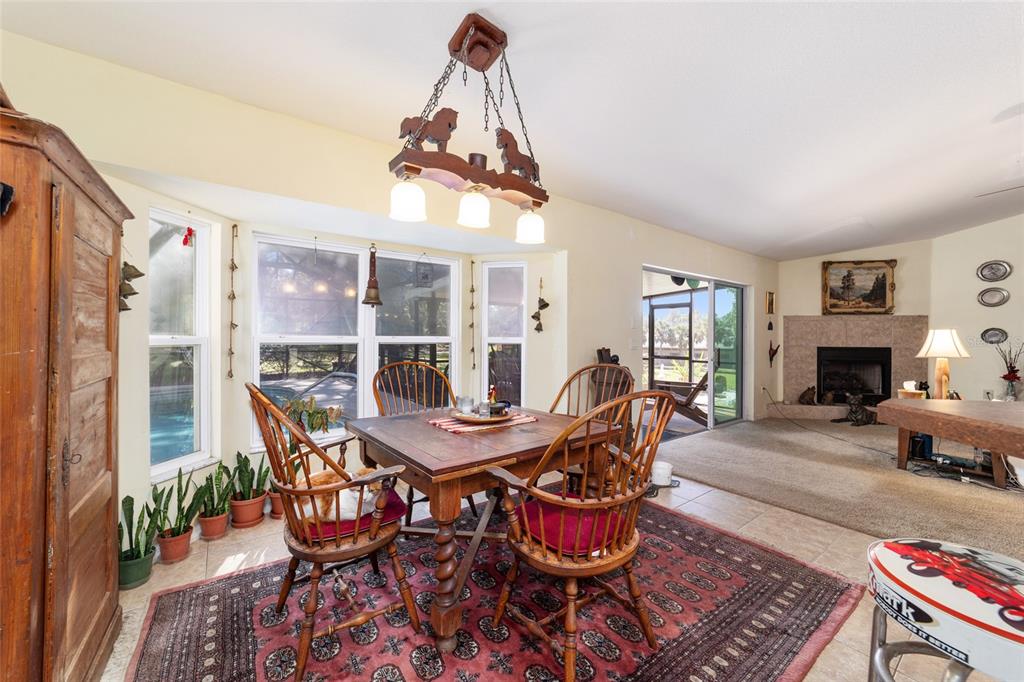 12932 Southwest 41st Place Ocala, FL 34481 - Photo 10 of 29 a dining room with furniture a chandelier and wooden floor