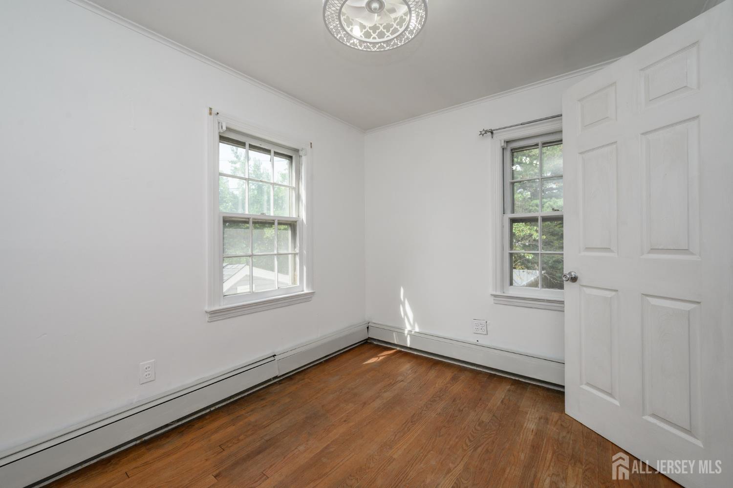 212 Echo Avenue Edison, NJ 08837 - Photo 25 of 42 a view of an empty room with wooden floor and a window