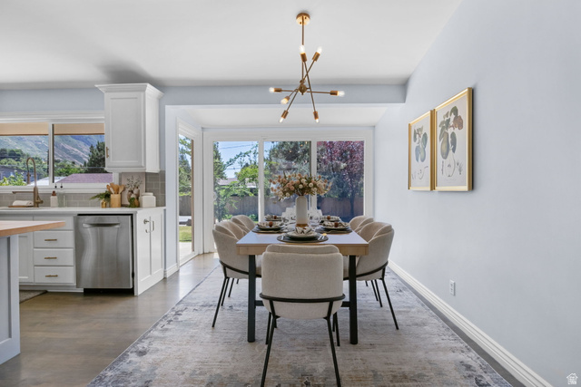576 East 3950 North Provo, UT 84604 - Photo 19 of 47 Open-concept dining area with a contemporary chandelier, light-toned wall finishes, and direct access to the outdoor space via sliding glass doors