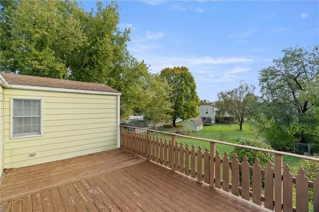 a view of a balcony with wooden floor and fence