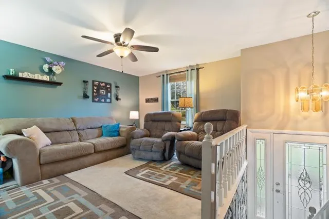 a living room with furniture a chandelier and a window