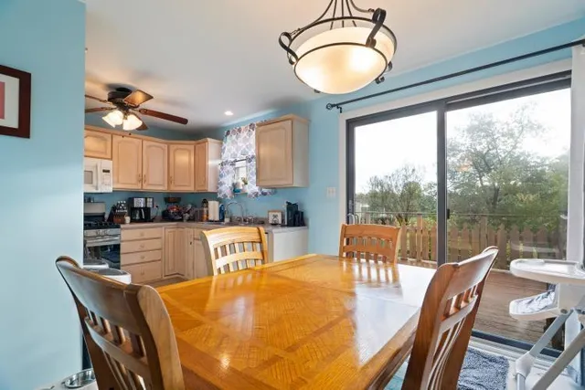 a kitchen with stainless steel appliances granite countertop a stove a refrigerator a kitchen island a table and chairs with the view of kitchen