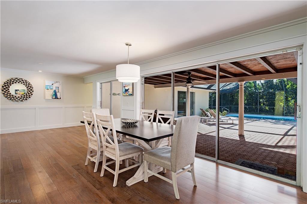 a dining room with wooden floor a glass table and chairs