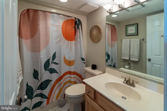 a bathroom with a sink mirror and toilet