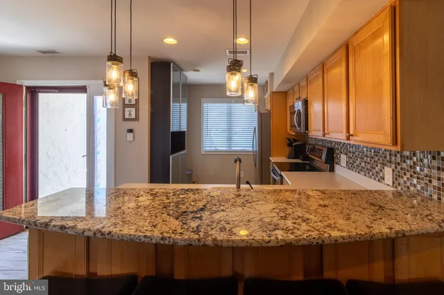 a kitchen with kitchen island granite countertop a sink a counter top space and cabinets