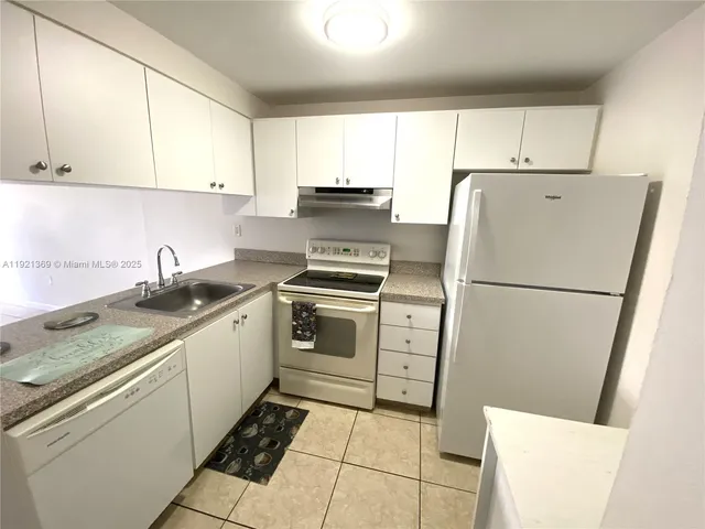 a kitchen with a refrigerator sink stove and cabinets