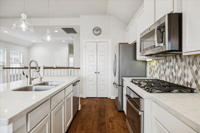 a kitchen with stainless steel appliances granite countertop a sink stove and cabinets