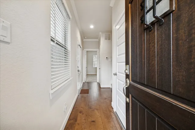 a view of a hallway with wooden floor and staircase