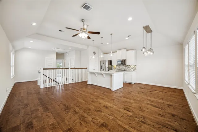 a view of kitchen with stove and white cabinets