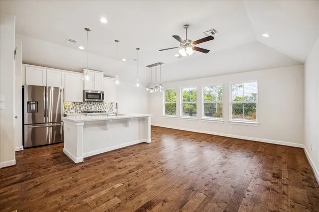 a view of kitchen with stainless steel appliances refrigerator stove microwave and cabinets