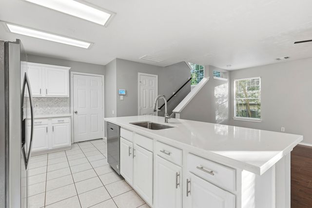 a kitchen with kitchen island a sink stove and refrigerator