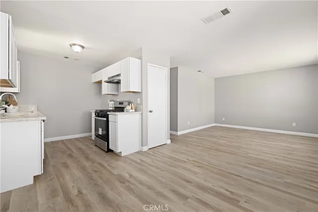 a kitchen with kitchen island a sink a stove a refrigerator and white cabinets
