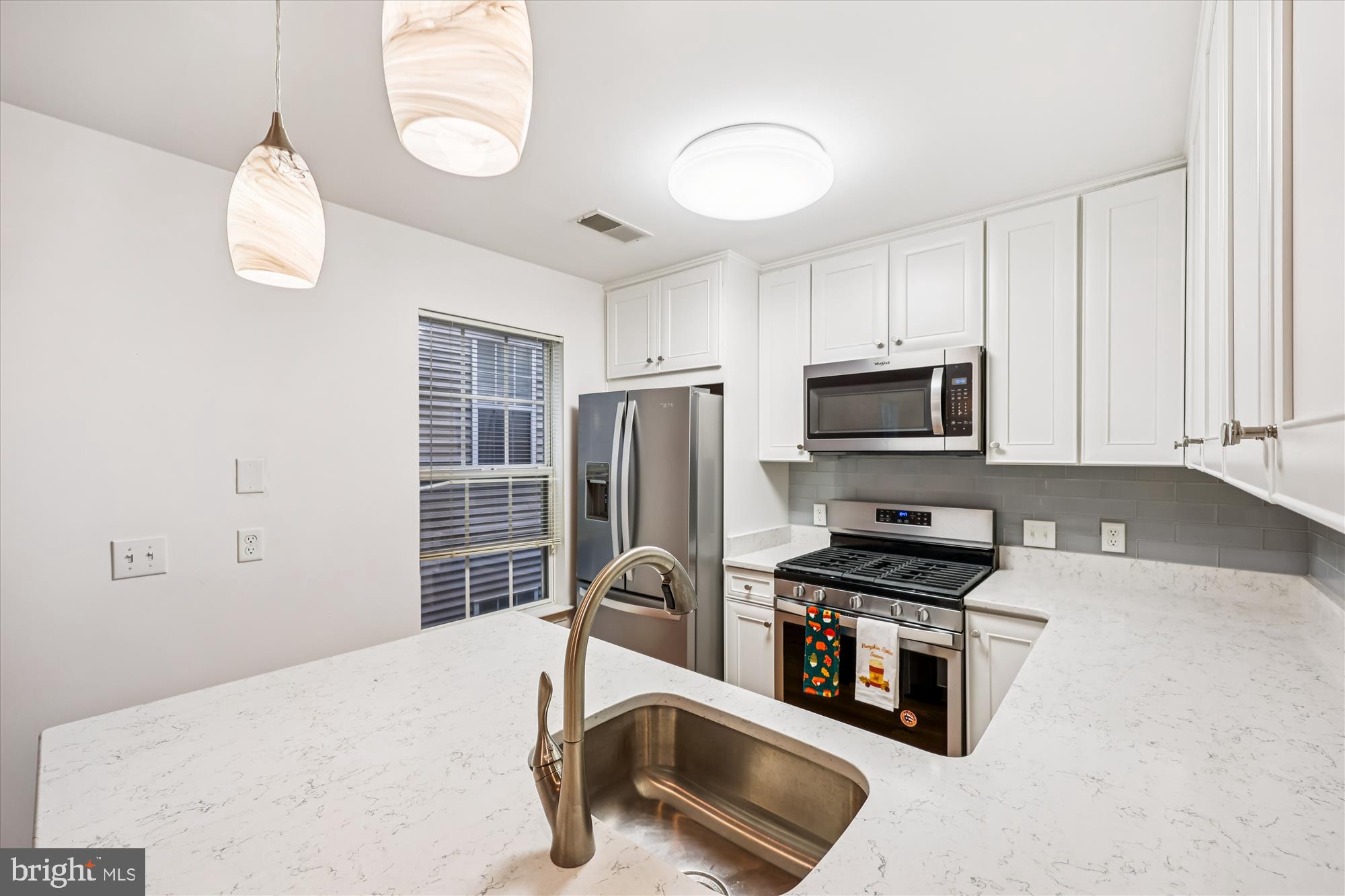 137 Timberbrook Lane, Unit 103 Gaithersburg, MD 20878 - Photo 13 of 51 a kitchen with stainless steel appliances a stove a sink and a microwave