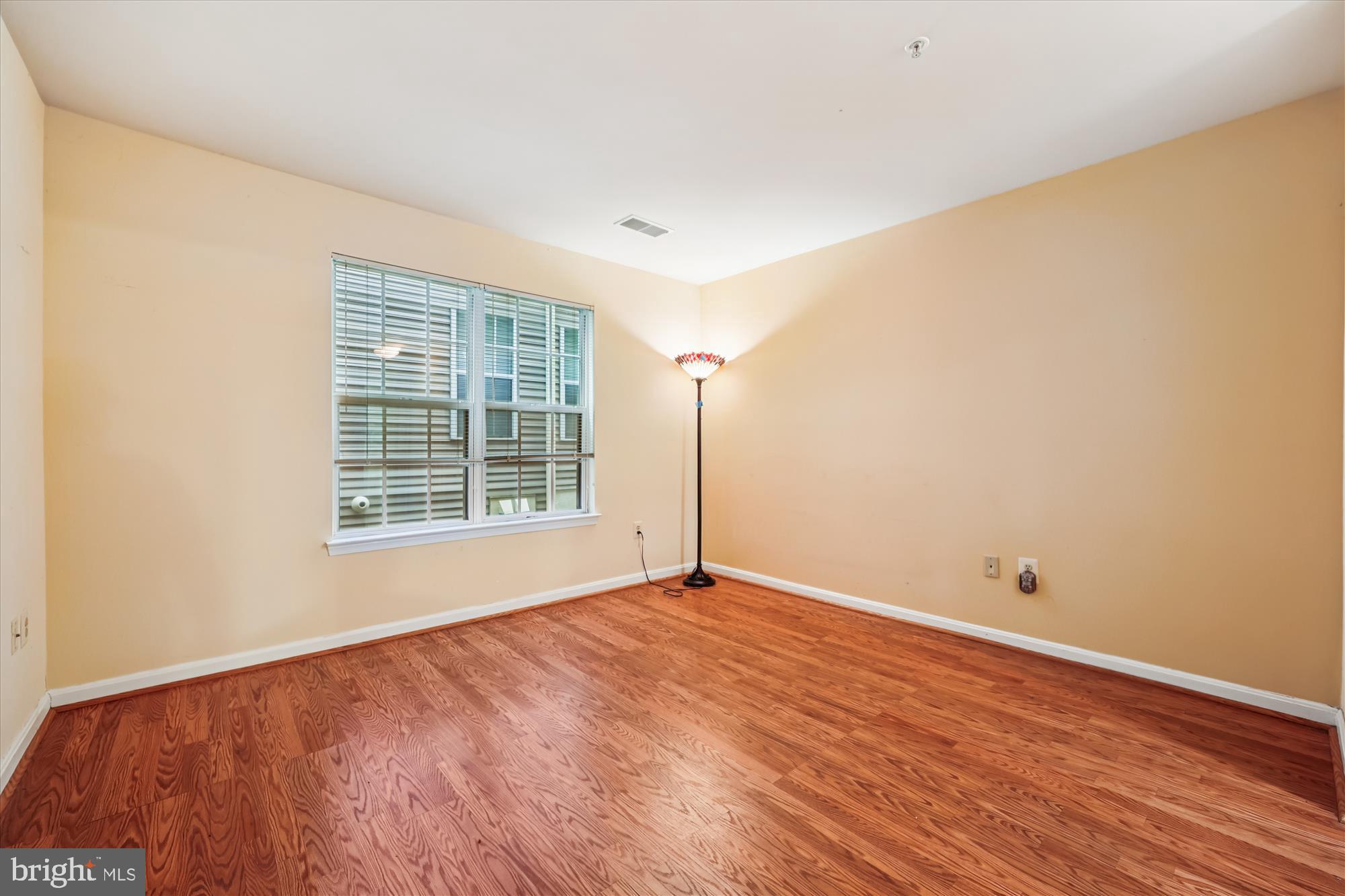 137 Timberbrook Lane, Unit 103 Gaithersburg, MD 20878 - Photo 19 of 51 a view of an empty room with wooden floor and a window