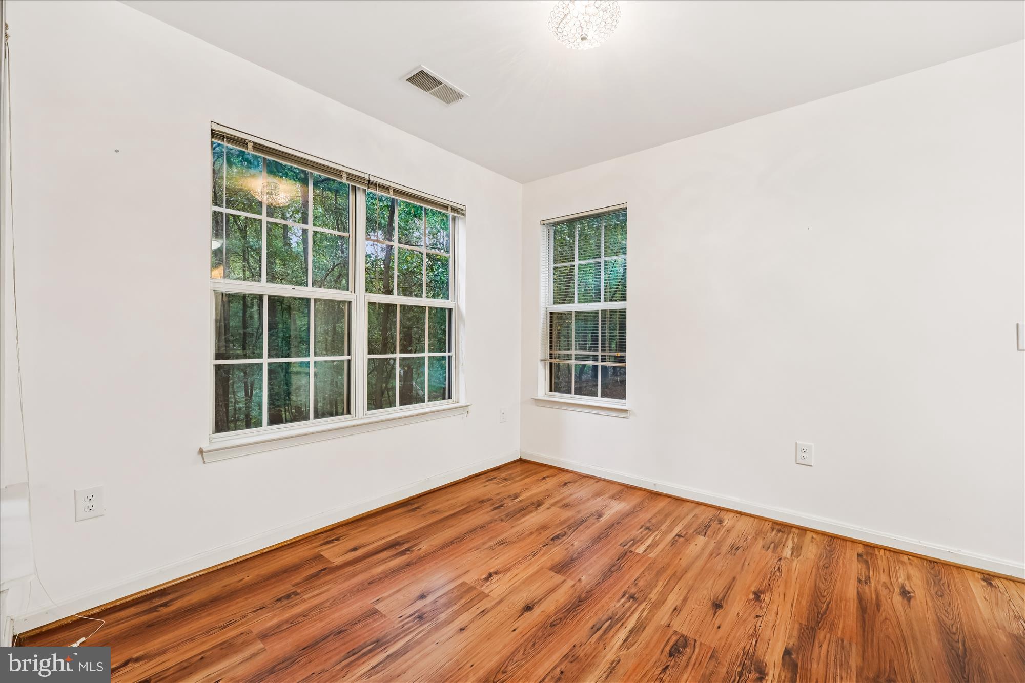 137 Timberbrook Lane, Unit 103 Gaithersburg, MD 20878 - Photo 7 of 51 an empty room with wooden floor and windows