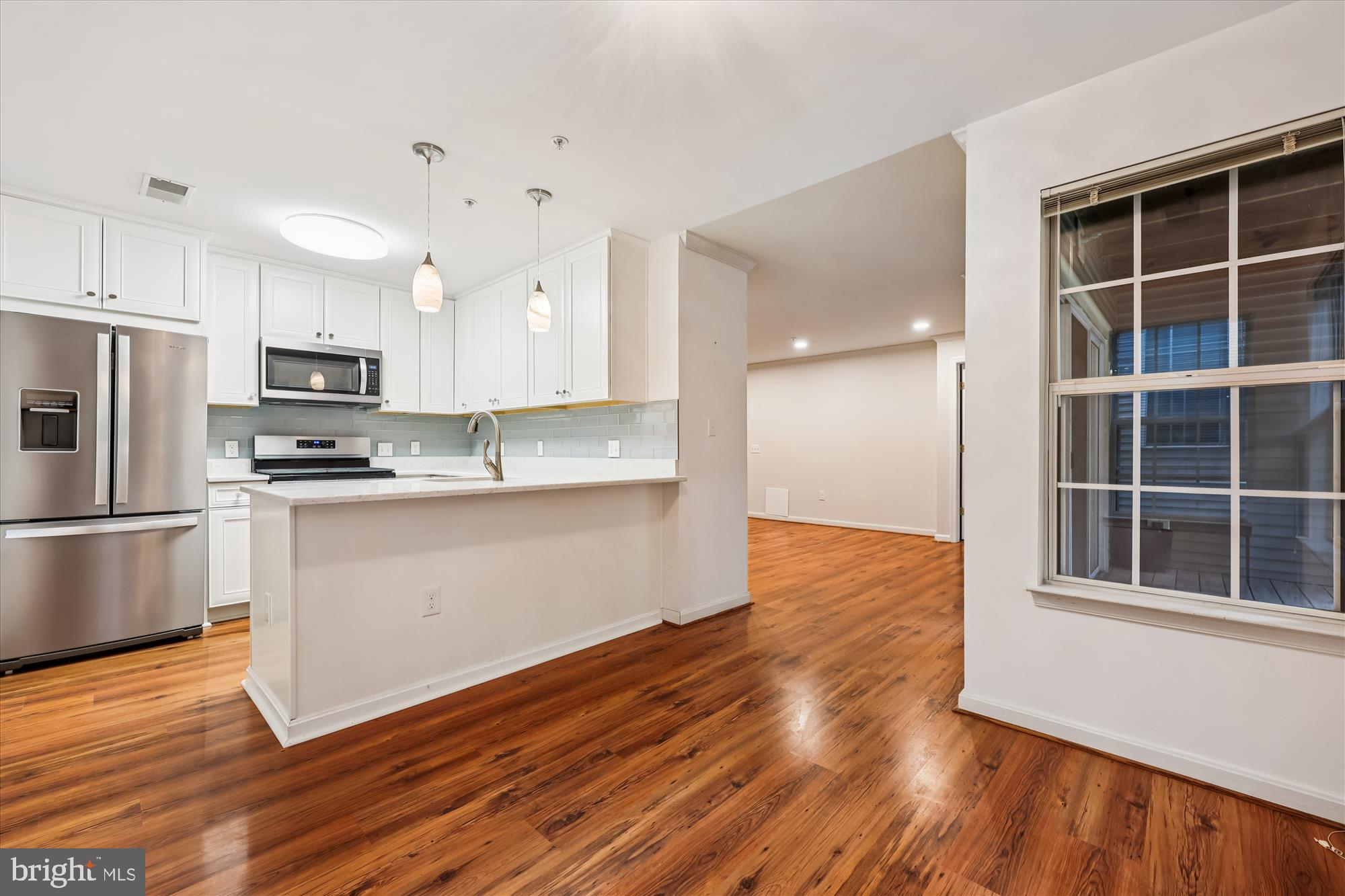 137 Timberbrook Lane, Unit 103 Gaithersburg, MD 20878 - Photo 9 of 51 a kitchen with granite countertop wooden floors stainless steel appliances and a window