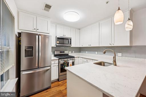 137 Timberbrook Lane, Unit 103 Gaithersburg, MD 20878 - Photo 10 of 51 a kitchen with a refrigerator a stove a sink and white cabinets