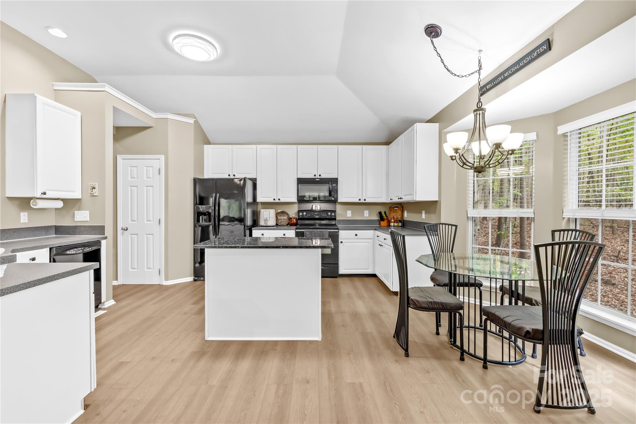 11113 Asbury Chapel Road Huntersville, NC 28078 - Photo 11 of 40 a kitchen with stainless steel appliances granite countertop a stove top oven a sink dishwasher a dining table and chairs with wooden floor