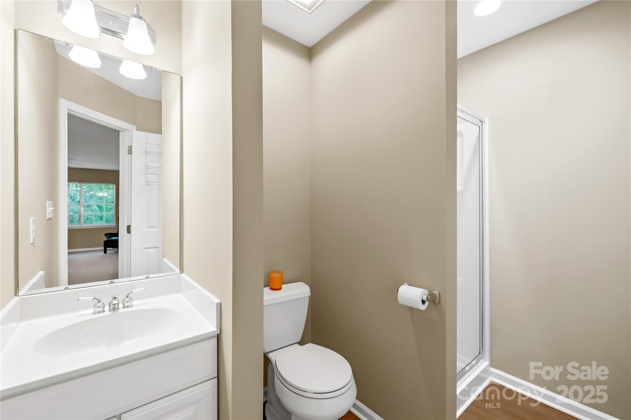 11113 Asbury Chapel Road Huntersville, NC 28078 - Photo 33 of 40 a bathroom with a sink a toilet a mirror and shower