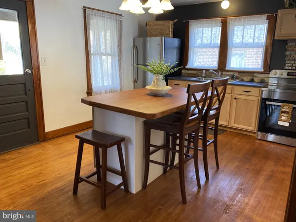 a view of a a dining room with furniture window and wooden floor
