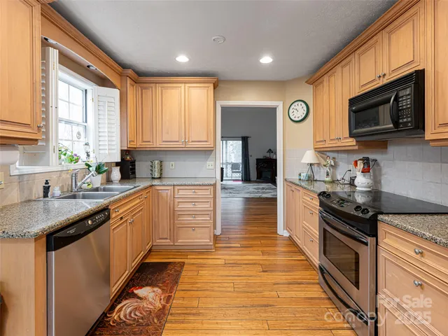 a kitchen with stainless steel appliances granite countertop a stove a sink and a microwave