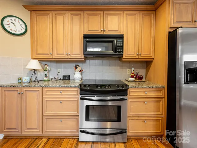 a kitchen with granite countertop white cabinets and stainless steel appliances