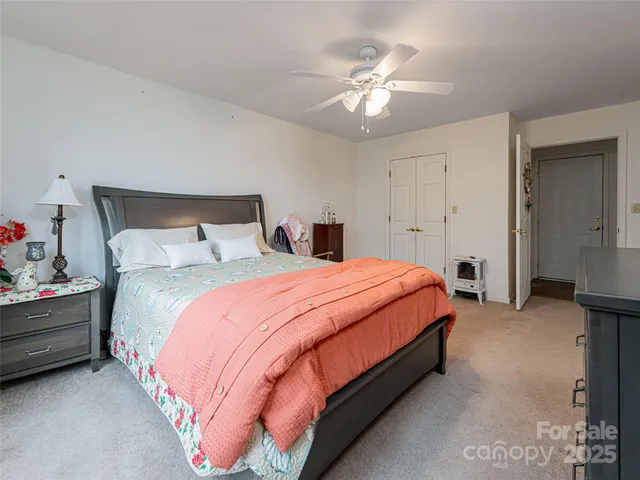 a spacious bedroom with a bed and a chandelier