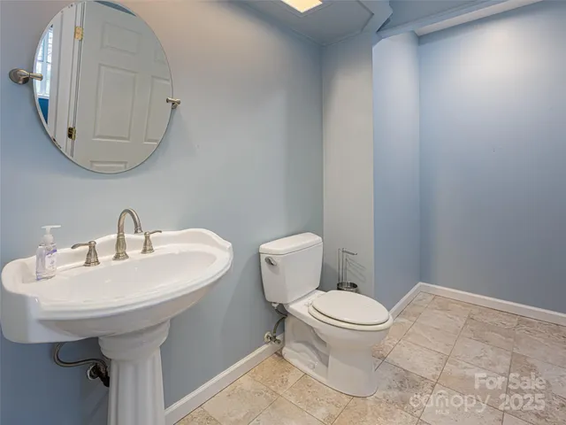 a bathroom with a sink a toilet and a mirror