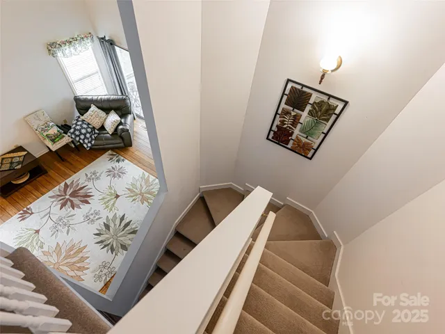 a view of a hallway with bed and wooden floor