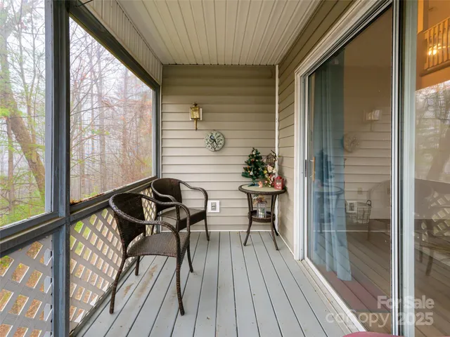 a view of a balcony with chairs and wooden floor