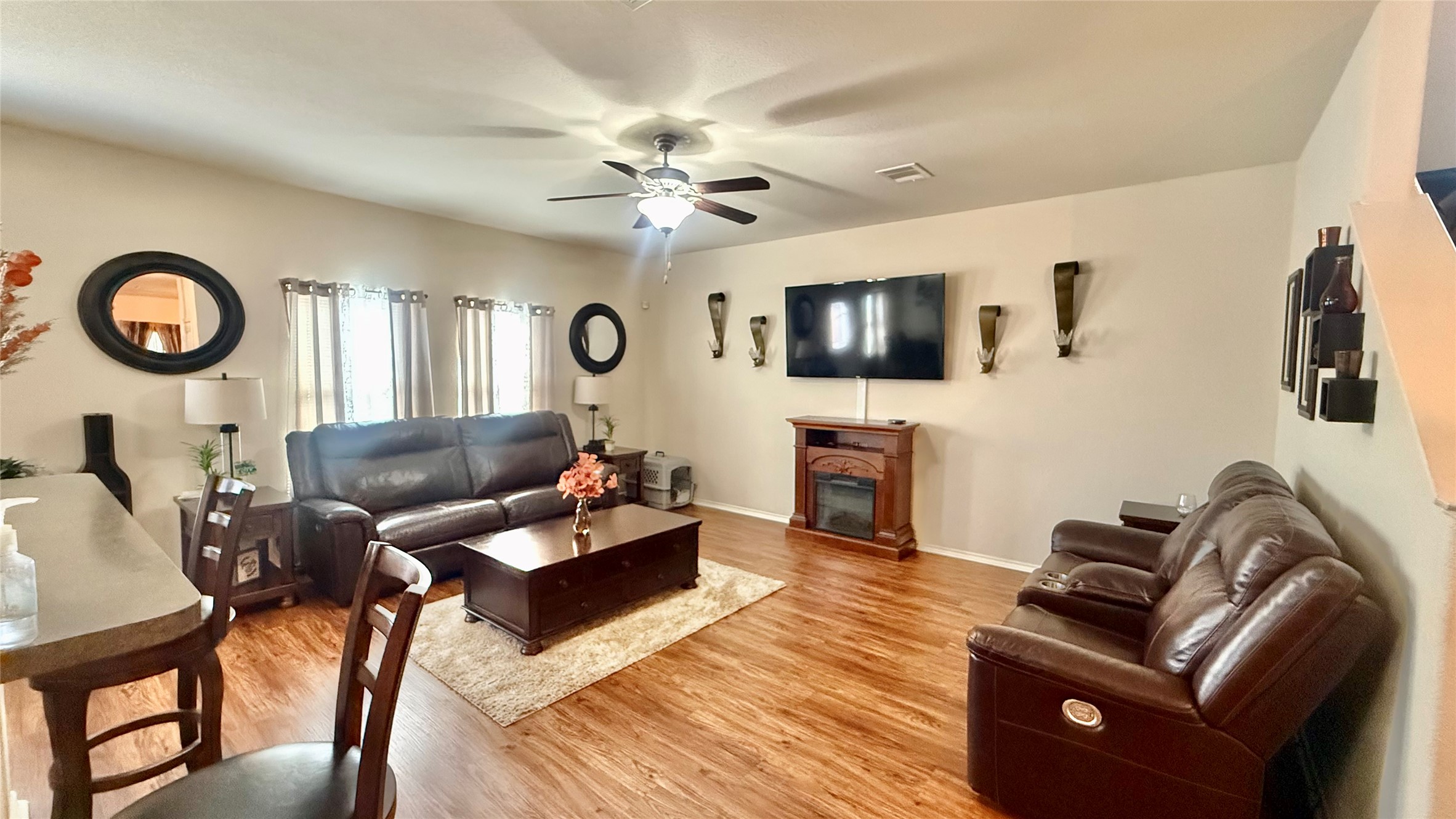 Warm wood flooring and an inviting fireplace anchor this comfortable living space.