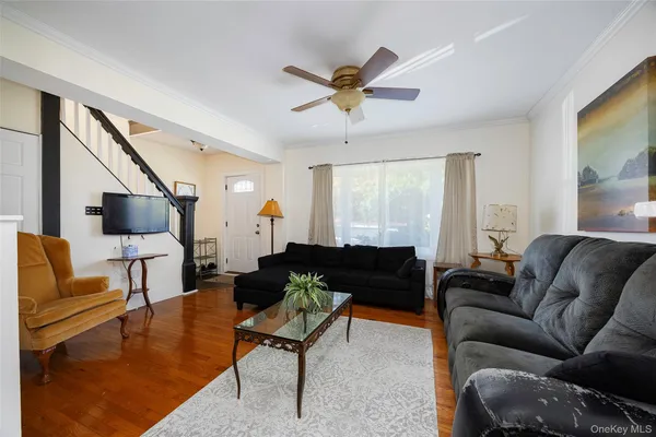 a living room with furniture ceiling fan and a window