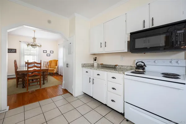 a kitchen with white cabinets and sink