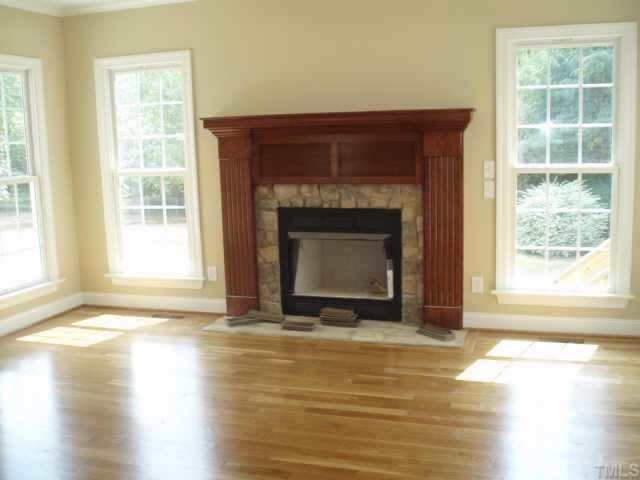 661 Shelley Road Raleigh, NC 27609 - Photo 2 of 8 a view of empty room with wooden floor and a fireplace
