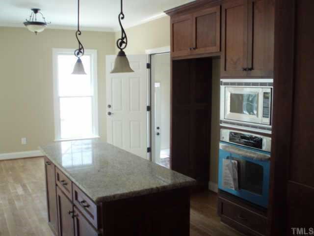 661 Shelley Road Raleigh, NC 27609 - Photo 5 of 8 a kitchen with a sink a refrigerator and cabinets