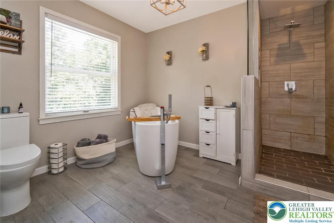 9461 Red Road Kempton, PA 19529 - Photo 29 of 55 Luxurious spa-like bathroom with a modern freestanding tub and a spacious walk-in shower.