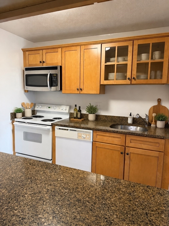 2 Victory Road, Unit 38 Lynn, MA 01902 - Photo 3 of 10 a kitchen with stainless steel appliances granite countertop a stove a sink and a microwave