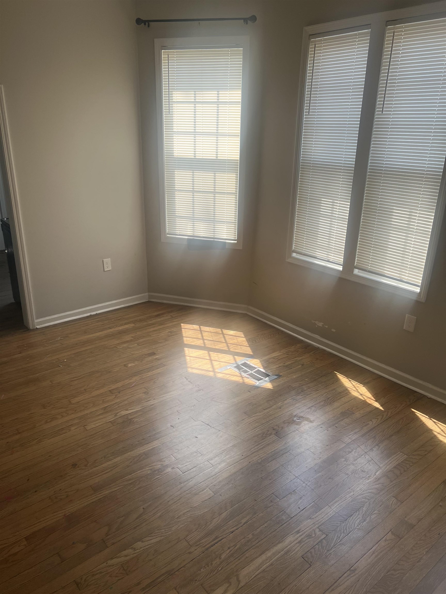 1353 Harbert Avenue Memphis, TN 38104 - Photo 7 of 18 an empty room with wooden floor and windows