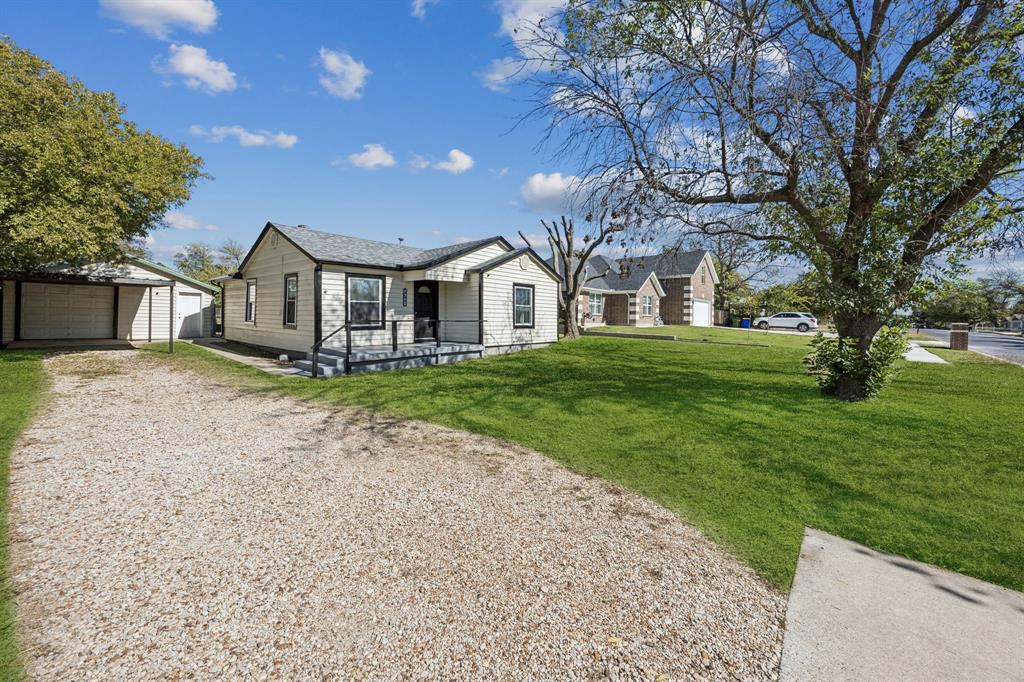 5621 Bonnie Drive Watauga, TX 76148 - Photo 7 of 40 a front view of a house with a garden and trees